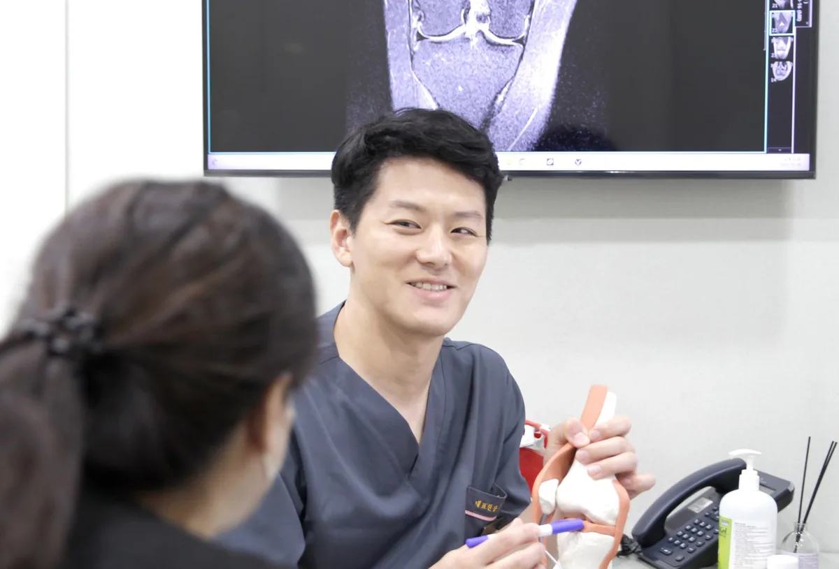 시대병원 김성욱 대표원장이 척추 모형으로 환자에게 설명하는 진료 모습